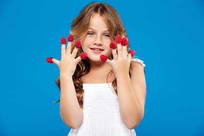 young pretty girl holding raspberry blue wall